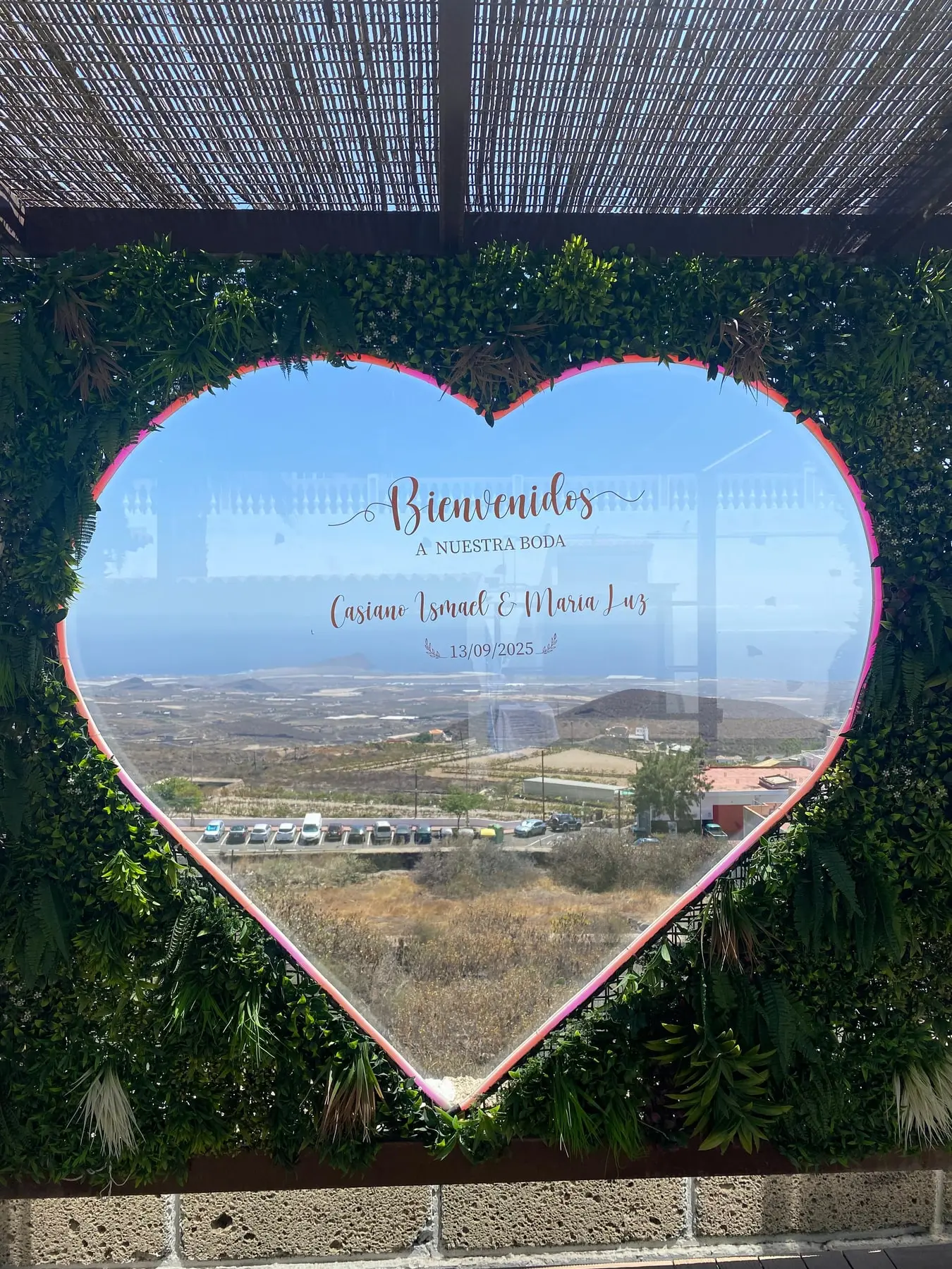 «Bienvenidos a nuestra boda»: el cartel de Casiano Ismael y María Luz en el corazón, con la costa detrás