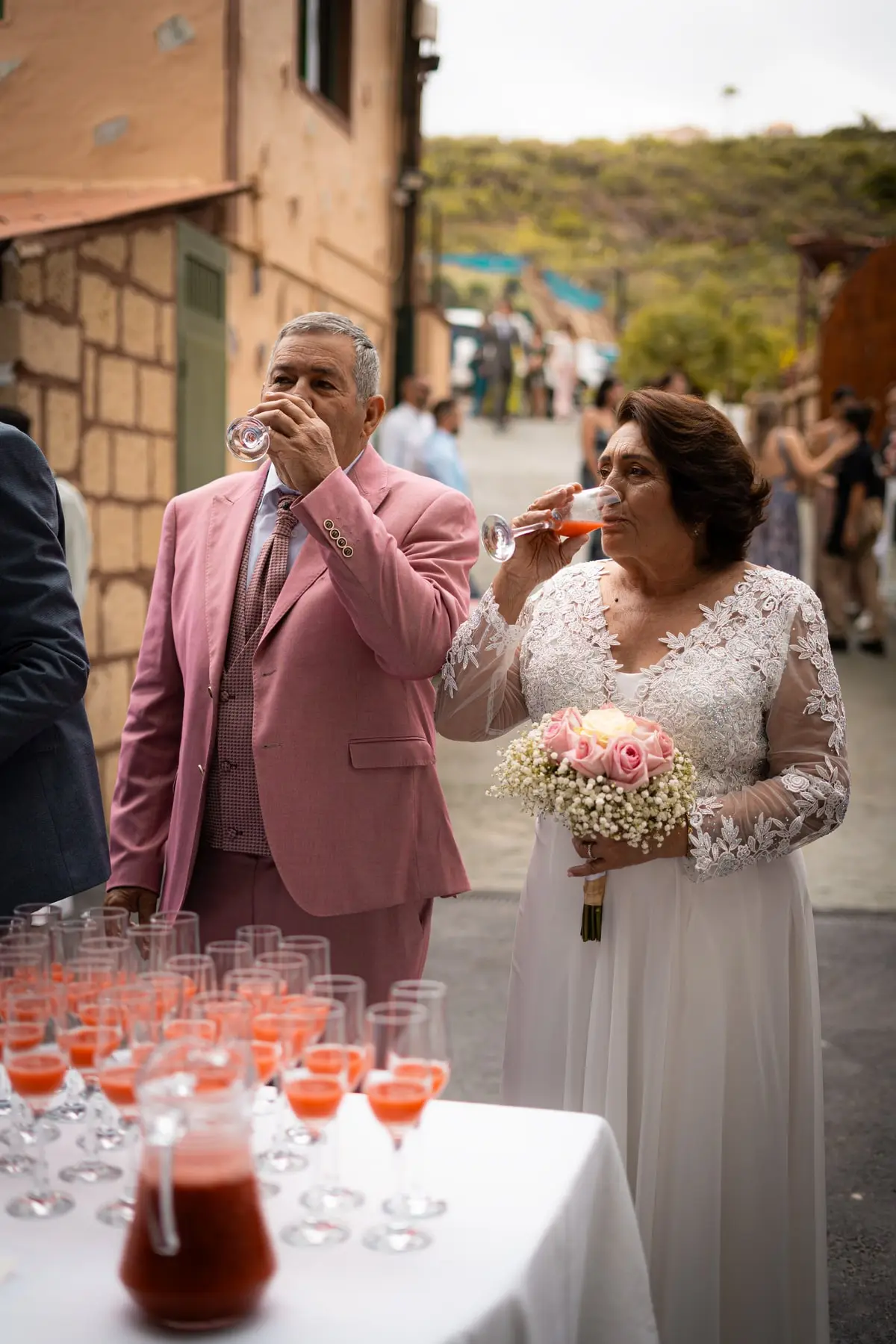 Los novios brindan con daiquiri de fresa junto a la mesa del cóctel