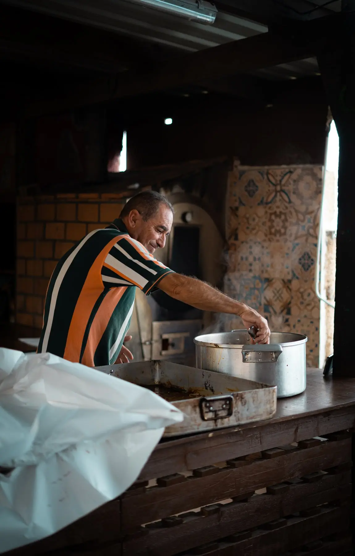 En la cocina, removiendo una olla grande junto al horno