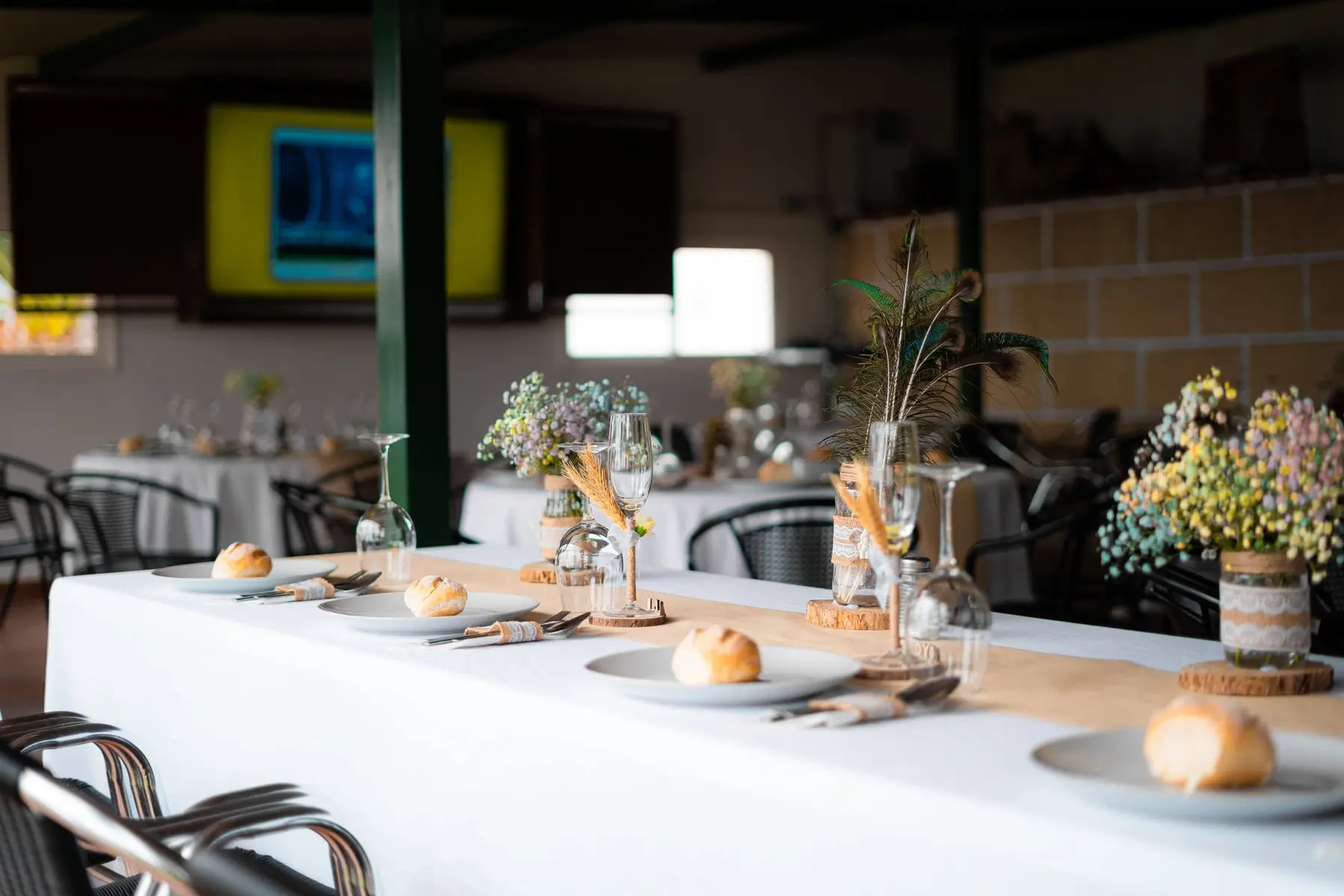 Mesa imperial con flores silvestres y pan en cada plato
